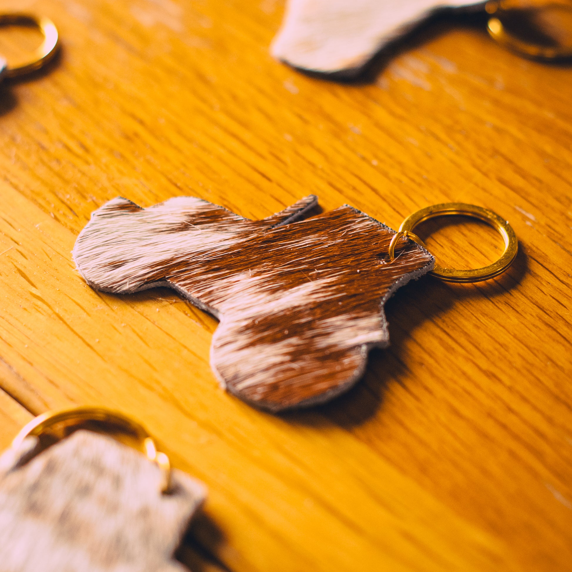 Dappled brown-and-white animal keyring with gold metal ring