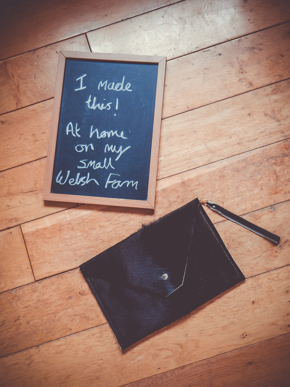 Dark cowhide envelope clutch bag with snap closure and metal strap