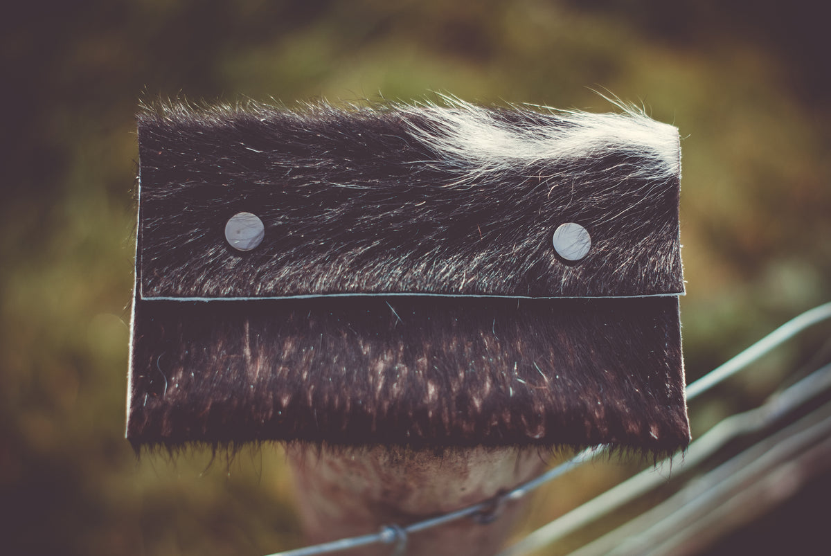 Small cowhide purse with dark leather flap and two silver snap buttons