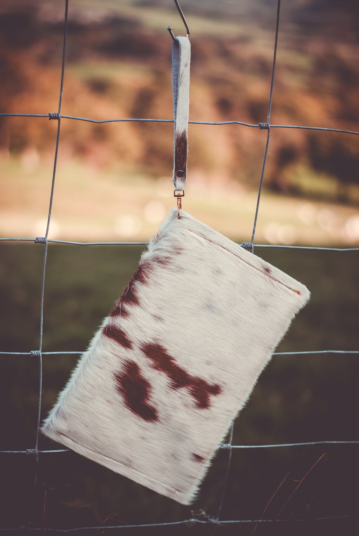 Cowhide envelope clutch bag with wrist strap, white with dark brown cowhide pattern