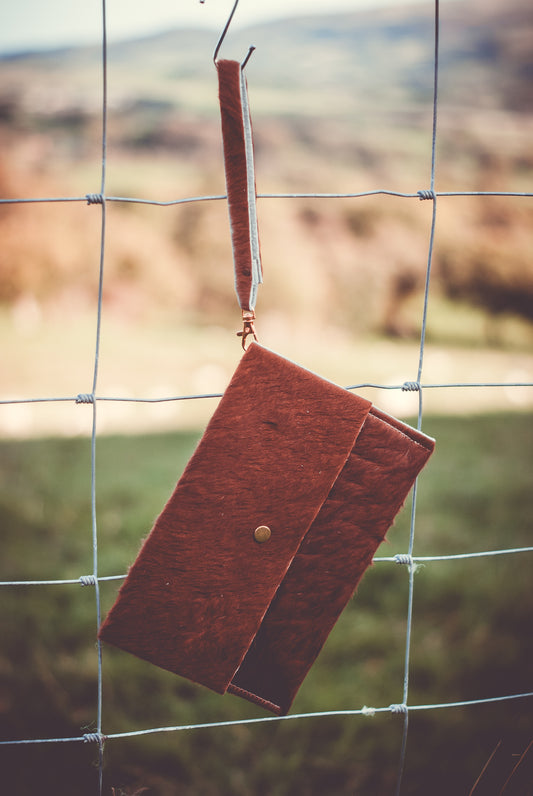 Cowhide clutch bag, compact burgundy-brown with flap and brass button