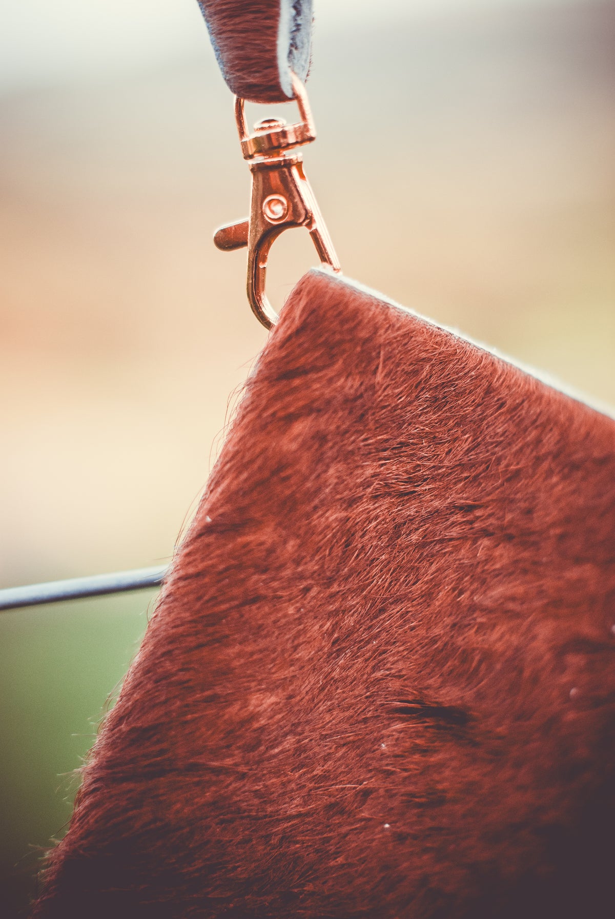 Cowhide clutch bag with wrist strap and metal clasp, textured burgundy-brown