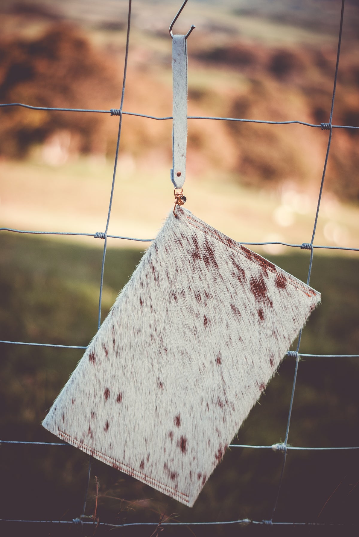 Cowhide envelope clutch bag, white with brown spots and wrist strap