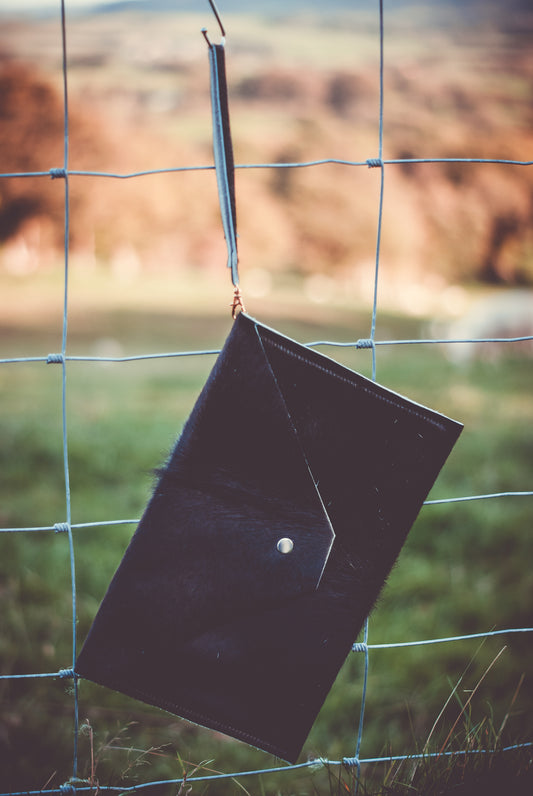 Black cowhide envelope clutch bag with snap button and short strap
