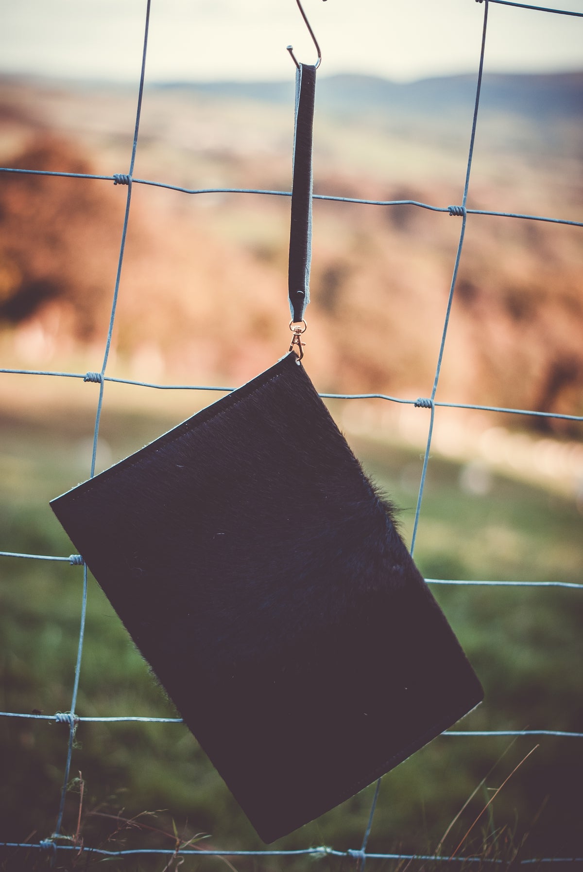 Dark cowhide envelope clutch bag with top handle strap