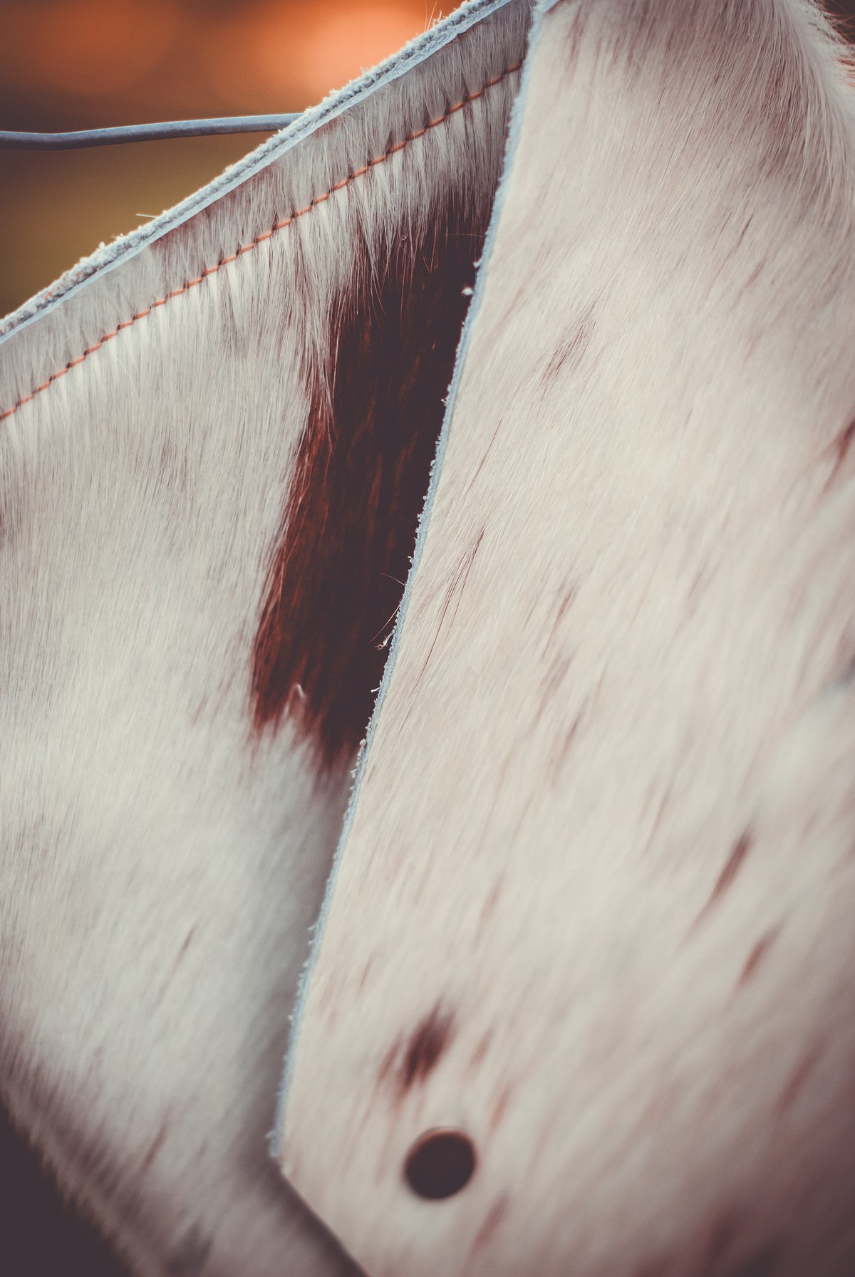 Cowhide envelope clutch bag side view, light fur with stitched seam and spot